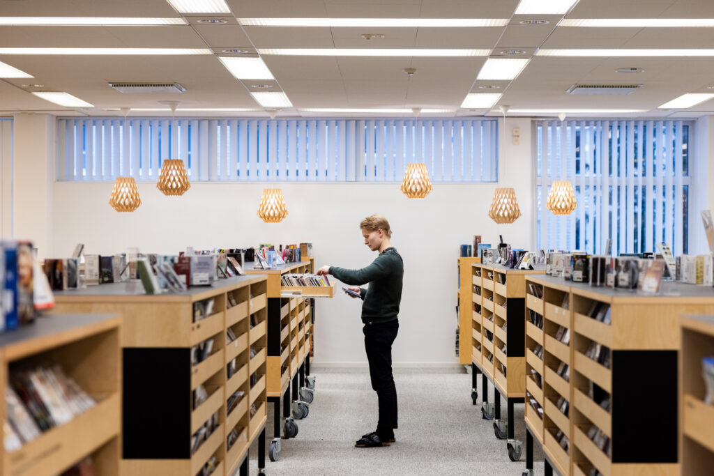 Henkilö selailee teoksia laatikossa Lahden kaupungin kirjastossa.