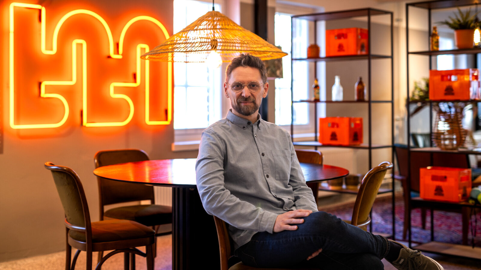 Mies istuu kahvilassa pöydän ääressä.