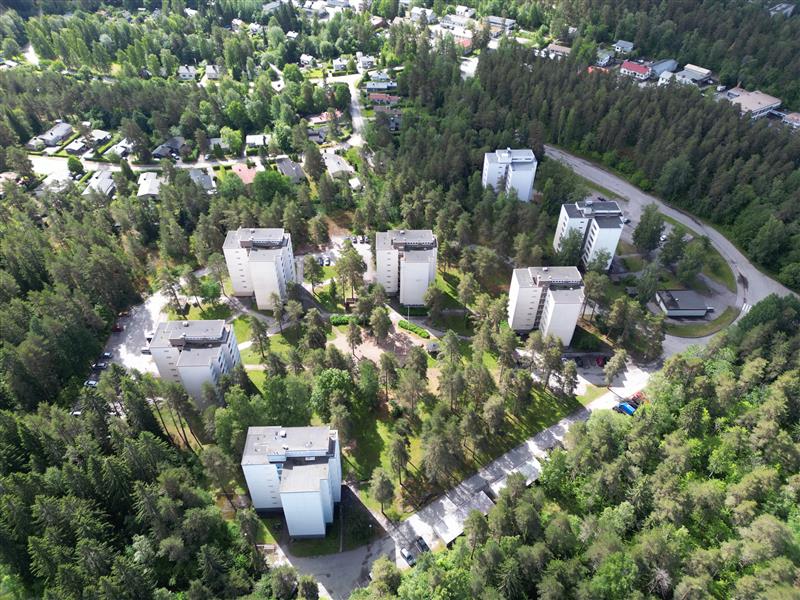 Ilmakuva Katajakadun asuinalueesta. Kuvassa paljon metsää, jonka joukosta pilkistää monia valkoisia kerrostaloja.