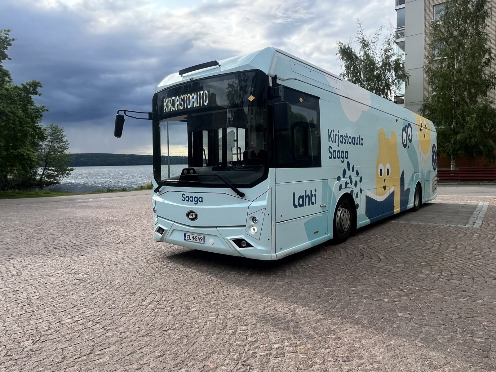 kirjastoauto kuvattuna kesäisessä maisemassa