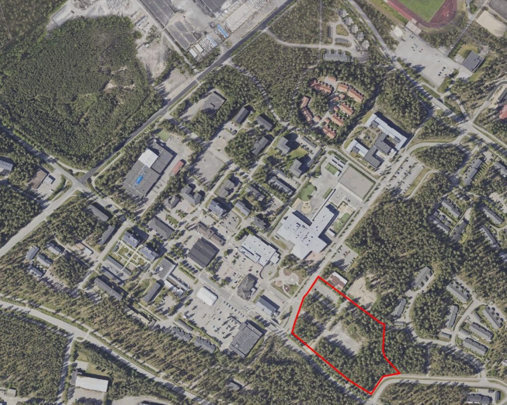 Ilmakuva Rakokiven liikekeskuksesta ja ympäristöstä. Ympärillä metsäisiä alueita. Suunnittelualue rajattuna kuvaan.