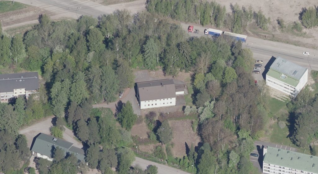 Tietotiellä sijaitsevan koulun ympärillä on pientaloja ja puustoa.