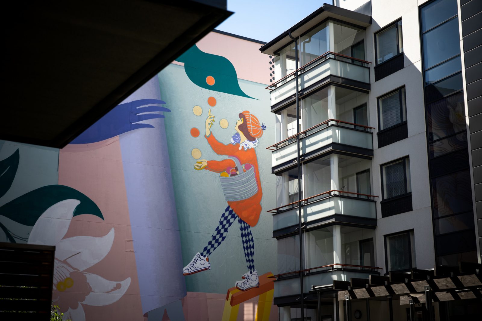 Museon seinään maalatussa muraalissa on jongleeraava tyttö. Block Party -muraalin toteuttivat taiteilijat Lehtinen + Rantala.