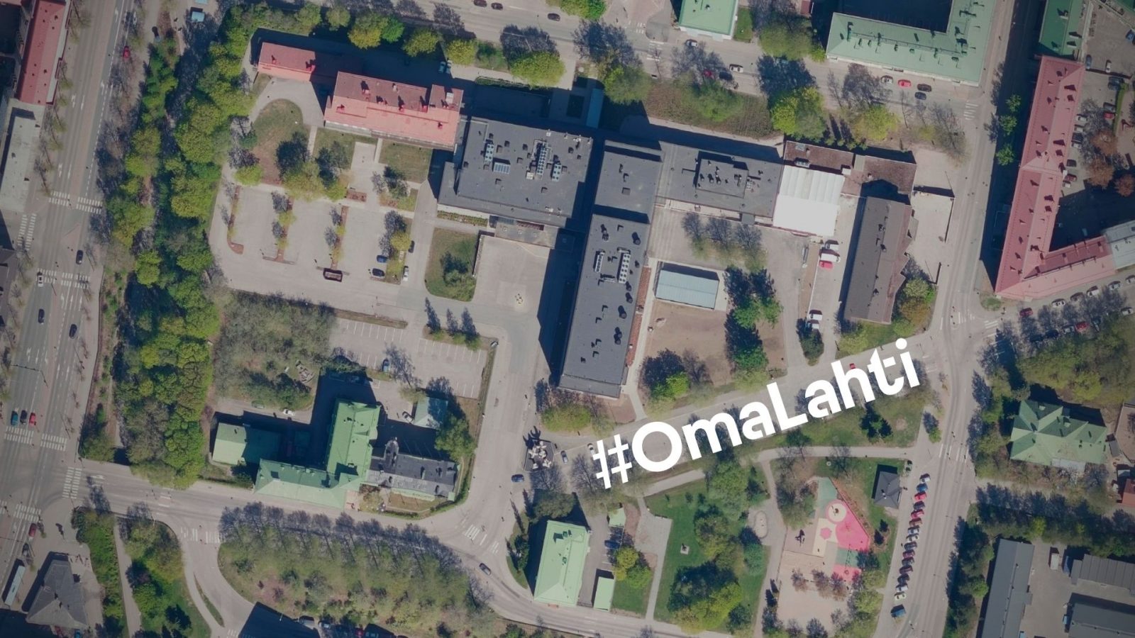 Kaupunginsairaala ja kansanopisto ilmasta kuvattuna. Ilmakuvan päällä teksti #OmaLahti.