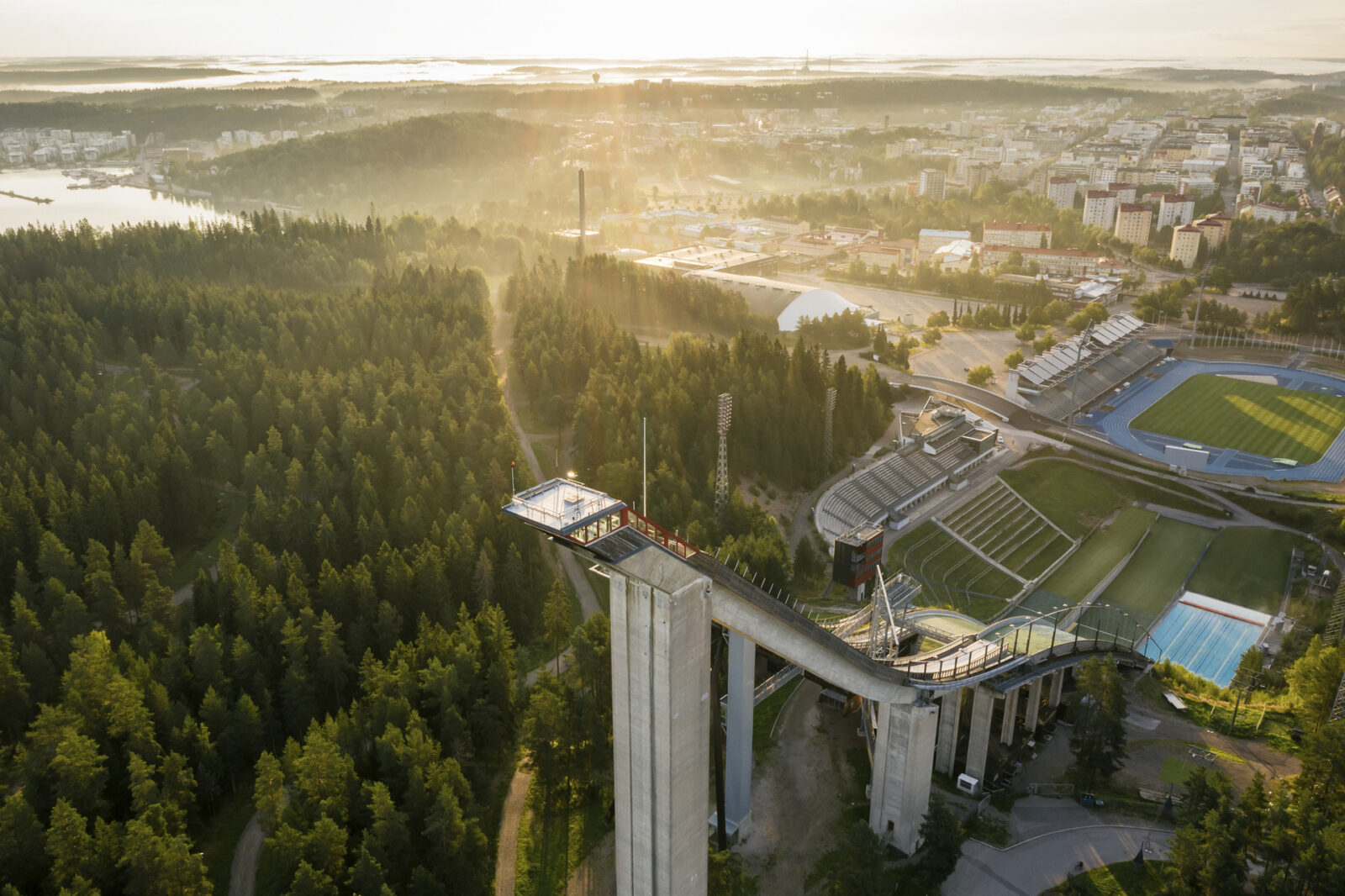 Lahden hyppyrimäet ja stadion ilmasta kuvattuna aamuauringossa