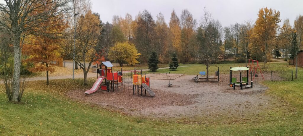 Kurppastenpuiston leikkialueen välineet syksyisessä maisemassa