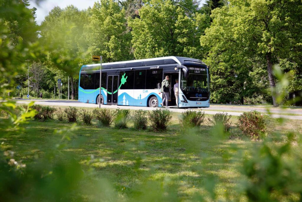 Linja-auto vehreässä maisemassa